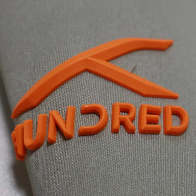 เสื้อสีซิลิโคนแบบกําหนดเอง ตราสีซิลิโคนที่สามารถล้างได้ 3D โลโก้สีซิลิโคนอ่อนโยน